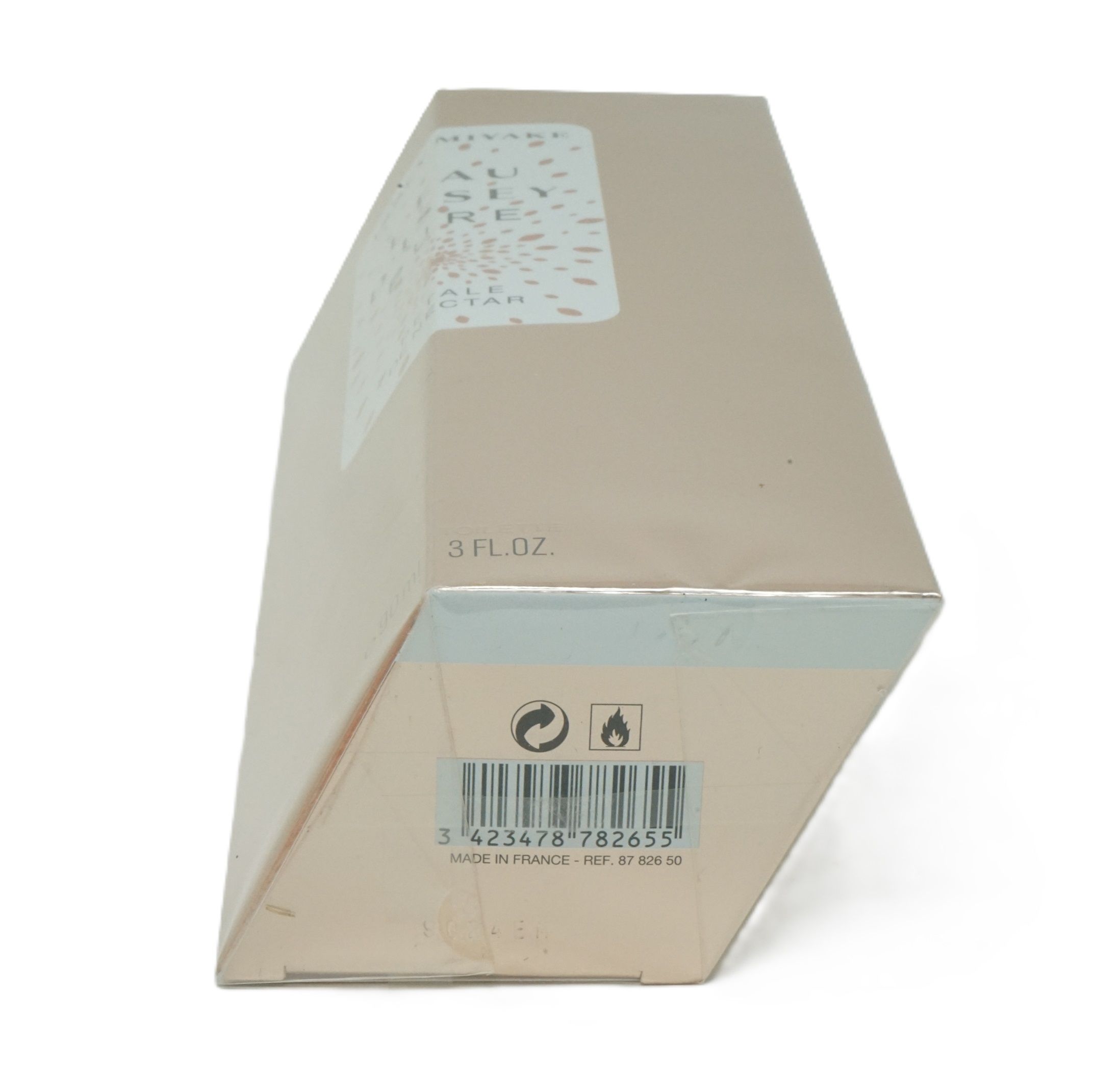 Scatola di cartone beige inclinata. Stampa con codice a barre, simboli di avvertimento e "3 FL.OZ.".