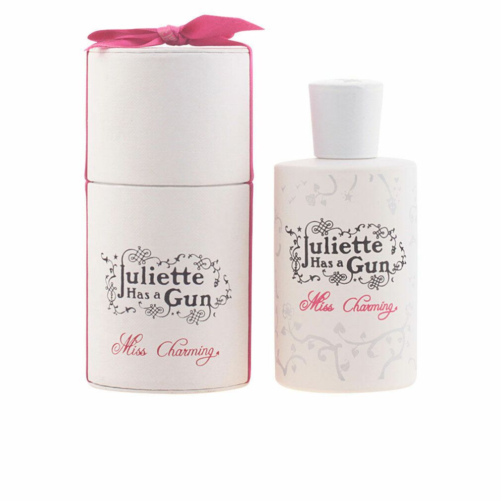 Flacone di profumo e confezione. Flacone bianco con tappo bianco. Fiocco rosa sulla confezione. Scritta 'Miss Charming'.