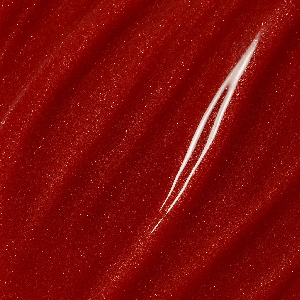 Primo piano di lucidalabbra rosso con pennellata bianca. Texture lucida.