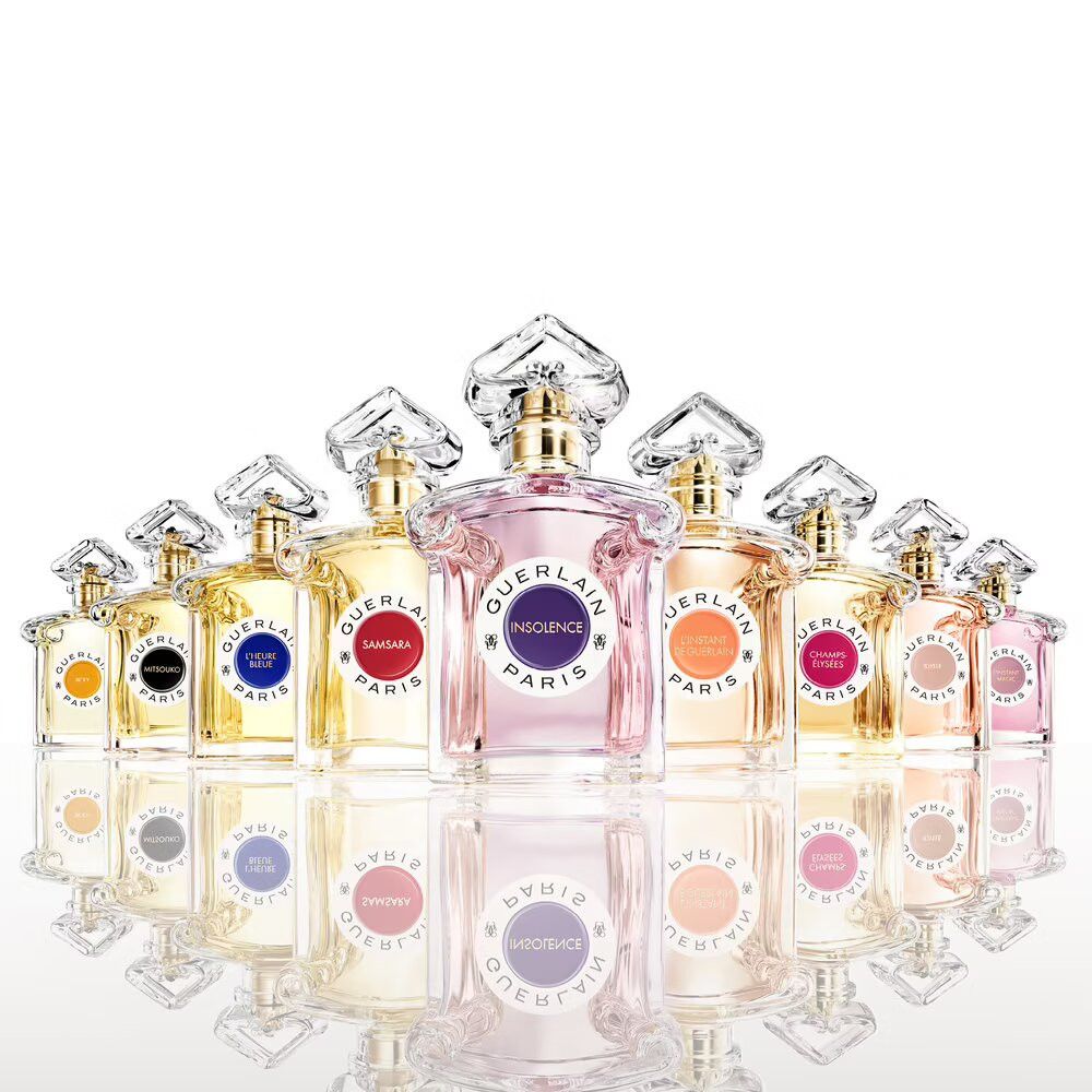 Diversi flaconi in vetro. Etichette con nomi diversi. Tappi dorati. Spruzzatori trasparenti. Riflesso.