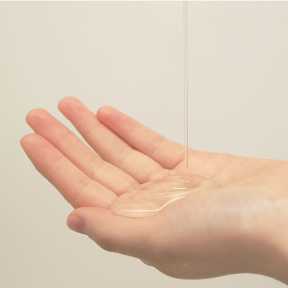 Liquido trasparente versato su una mano. La mano è leggermente aperta, il liquido forma una pozza.