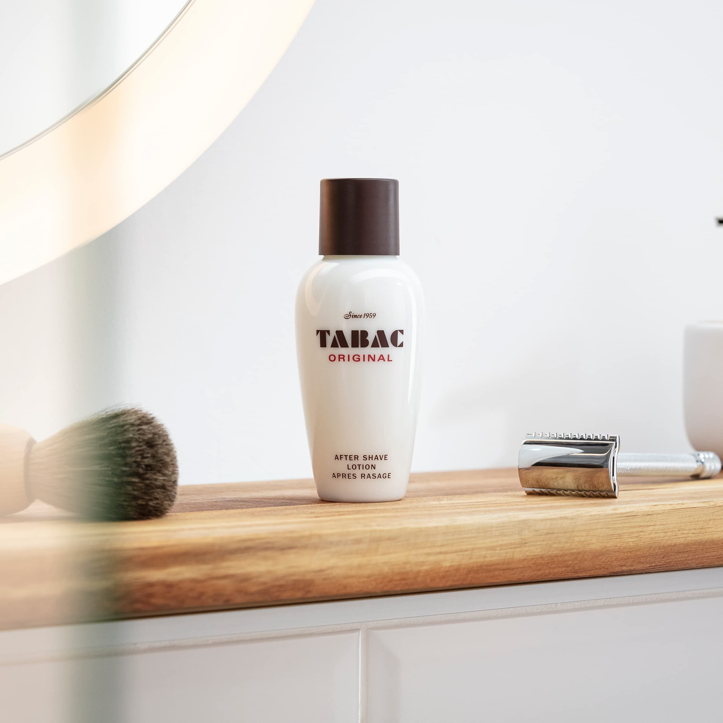 Flacone bianco con tappo marrone su tagliere in legno. Pennello da barba e rasoio accanto.