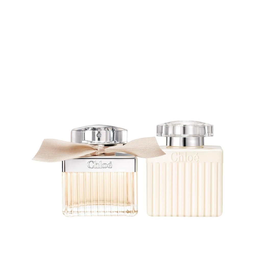 Due flaconi di profumo affiancati. Entrambi hanno tappi argentati e fiocchi. Il nome del marchio è visibile sui flaconi.