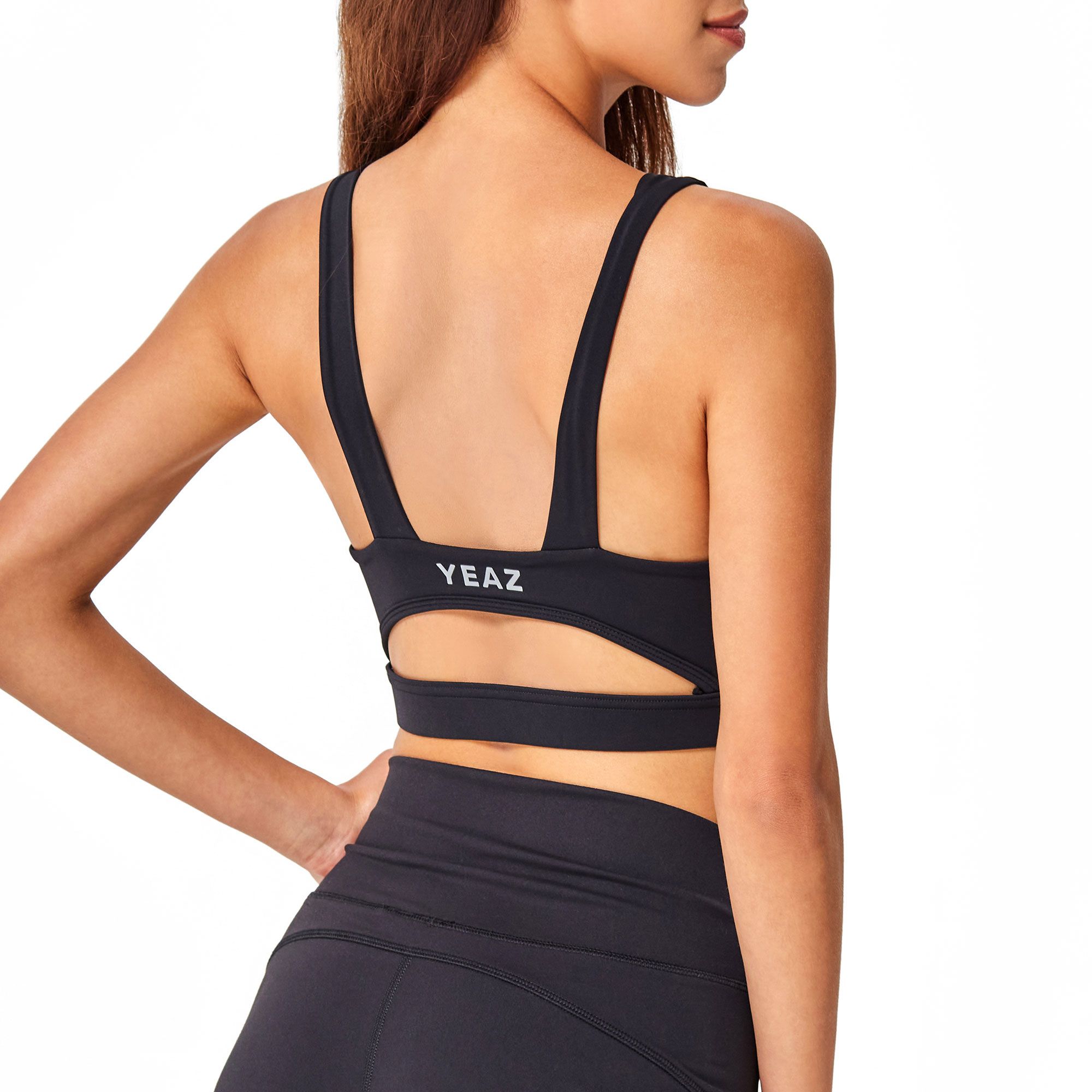 Reggiseno sportivo nero con logo "YEAZ" sul retro e dettaglio cut-out.