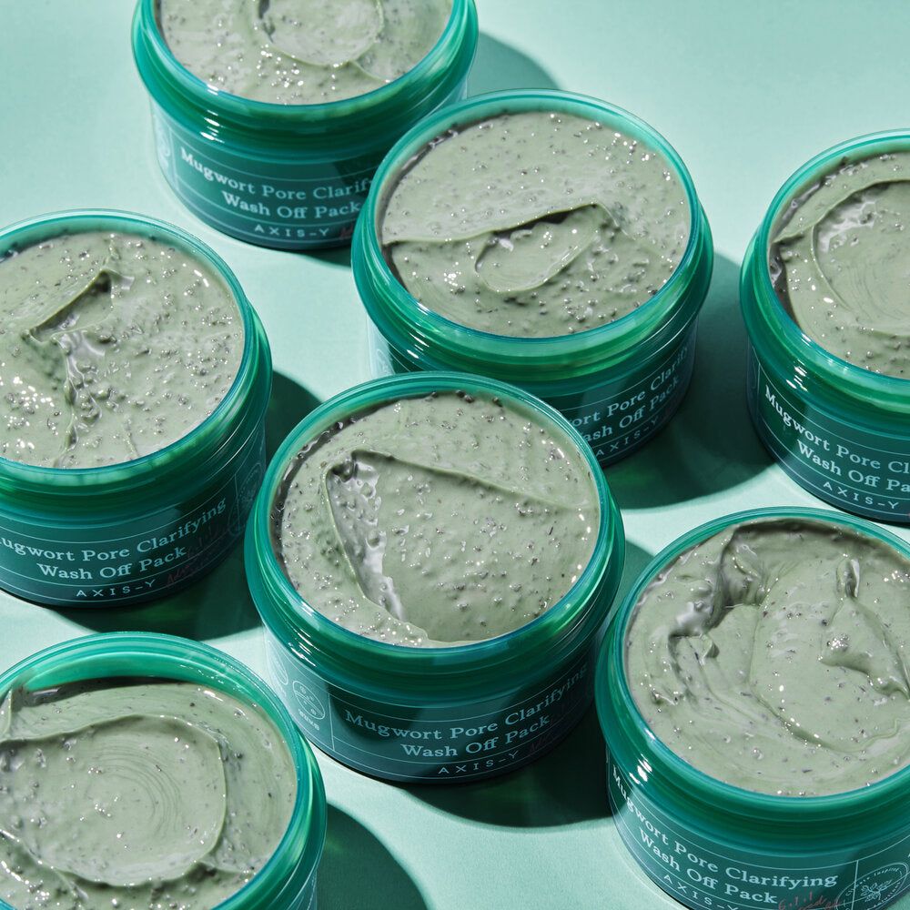 Diversi vasetti verdi di maschera per il viso. Scritta: Mugwort Pore Clarifying Wash Off Pack. Marchio: AXIS-Y.