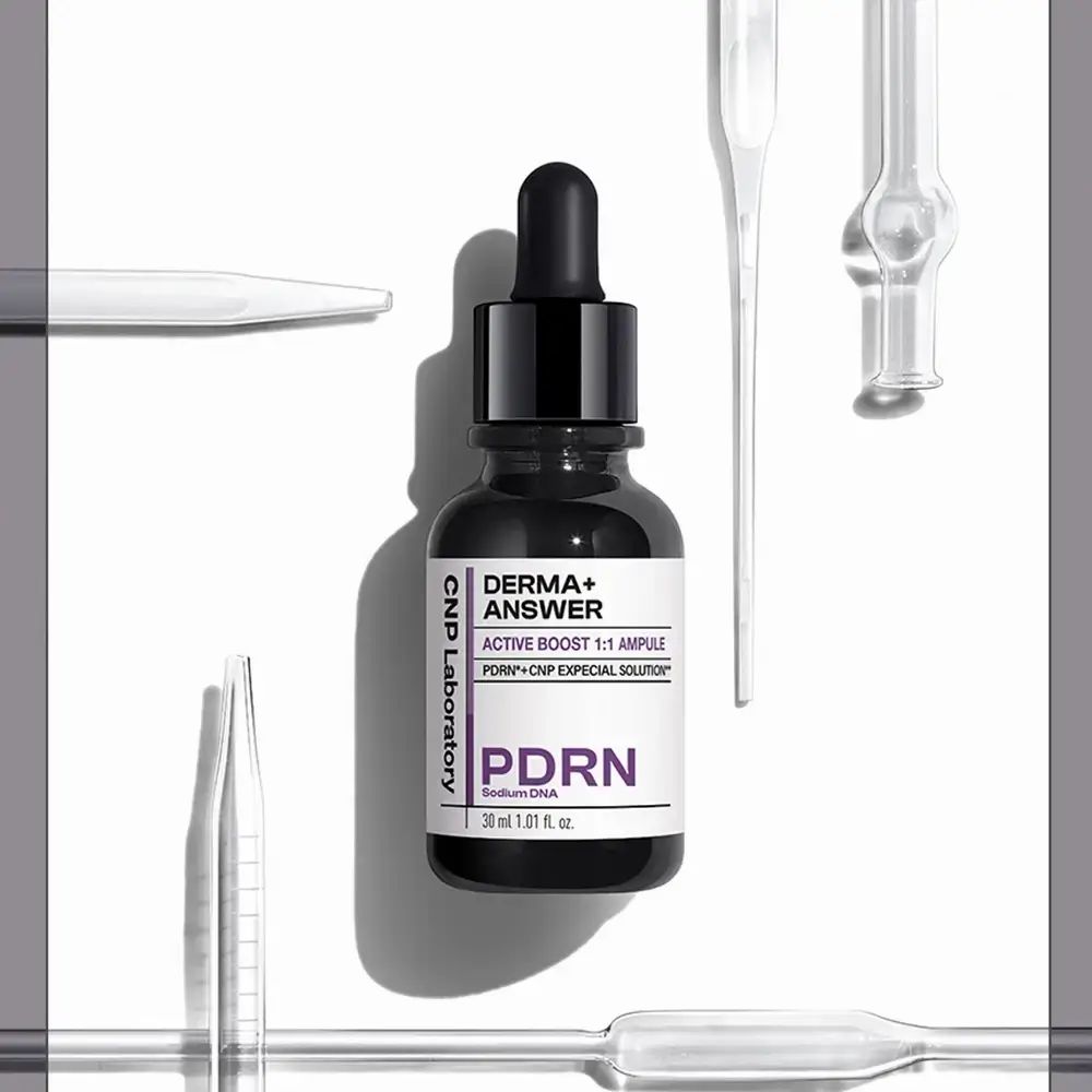 Flacone di vetro scuro con pipetta. Etichetta: DERMA+ ANSWER, PDRN, CNP Laboratory. Pipette sullo sfondo.