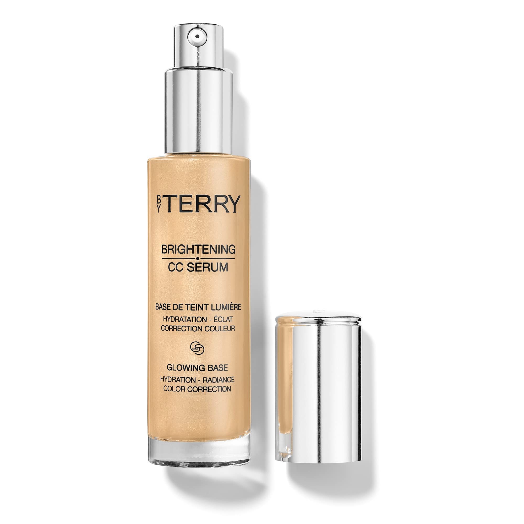 Flacone in vetro beige con tappo argentato aperto. Testo: "TERRY", "BRIGHTENING CC SERUM", "GLOWING BASE".