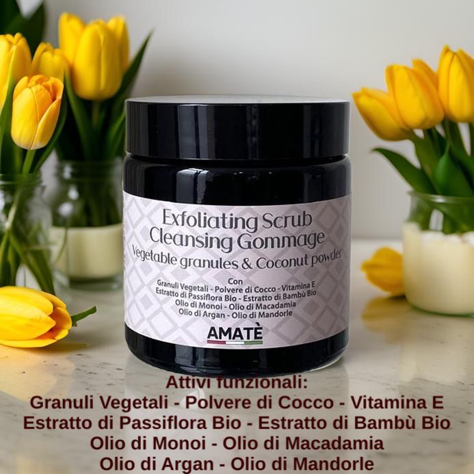 Barattolo scuro con etichetta, circondato da tulipani gialli. Testo: Exfoliating Scrub Cleansing Gommage, Vegetable granules & Coconut powder. Marchio: AMATÈ.