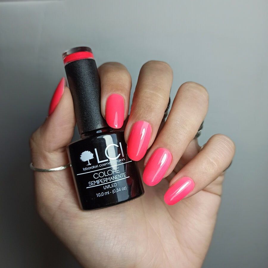 Mano con unghie smaltate e flacone di smalto. Scritta: LCI, COLORE SEMIPERMANENTE, UVLED.