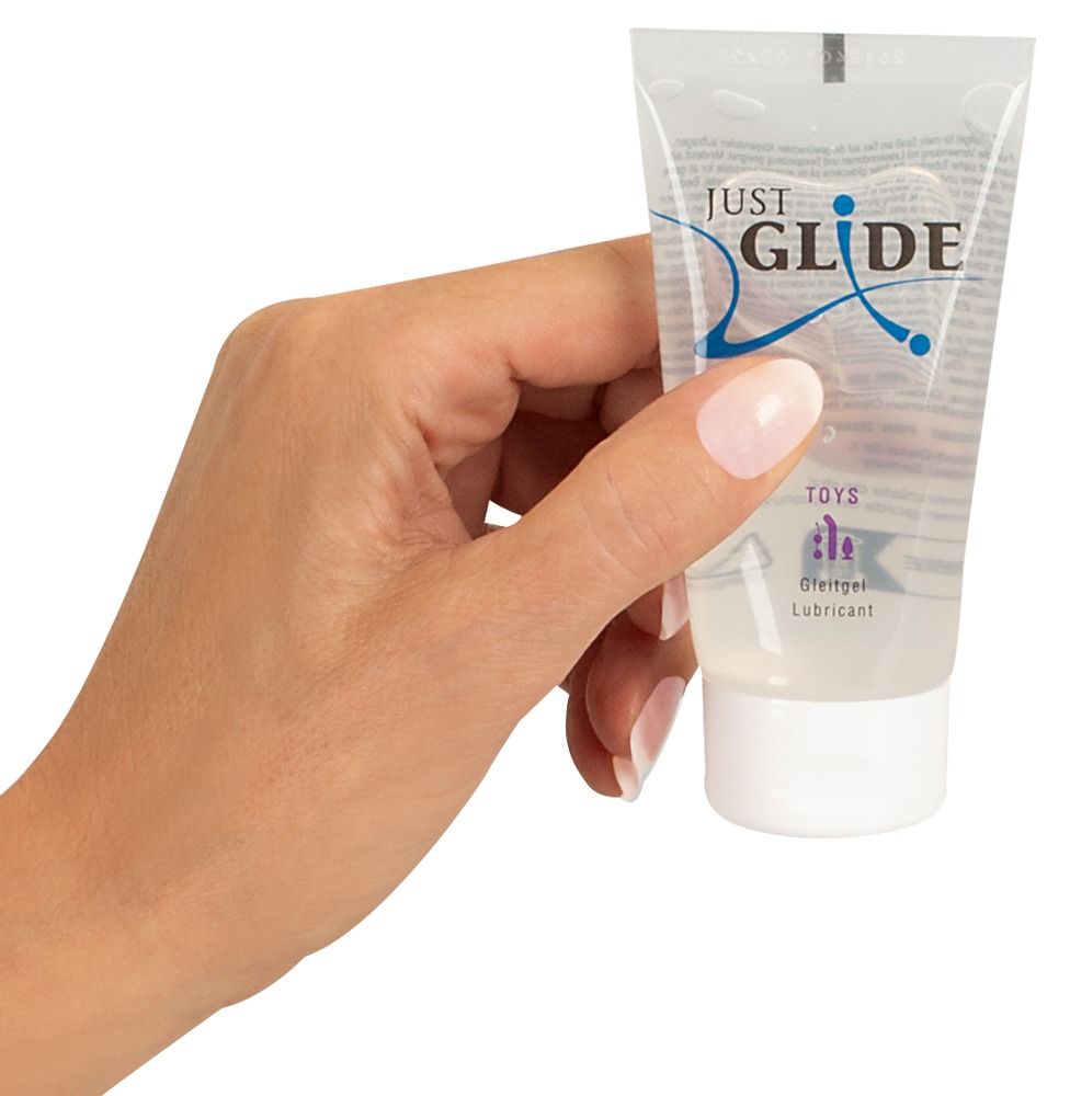 Mano che tiene un tubo di lubrificante Just Glide per giocattoli.
