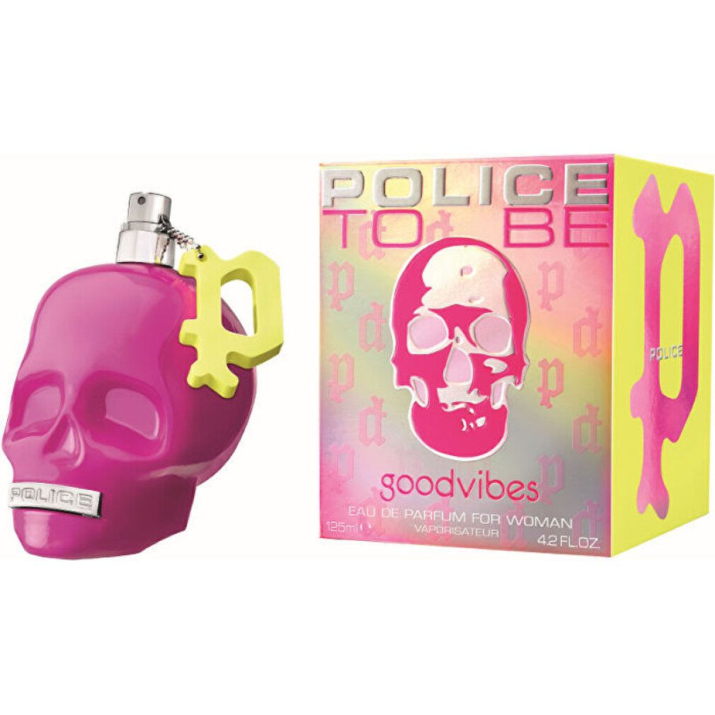 Flacone di profumo rosa a forma di teschio con ciondolo giallo e scatola abbinata.