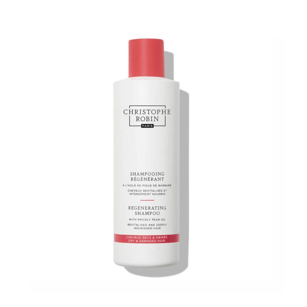 Flacone di shampoo bianco con tappo rosso. Testo: Christophe Robin, Shampooing Régénérant, Regenerating Shampoo. Per capelli secchi e danneggiati.
