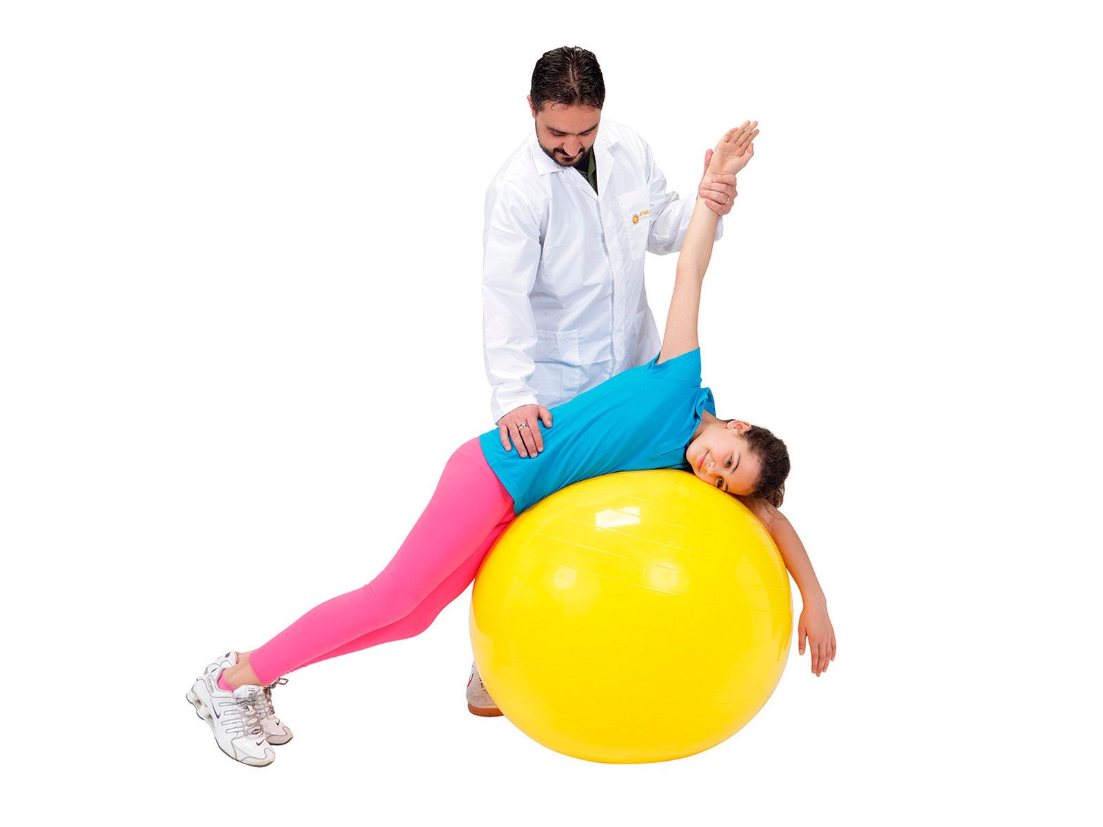Un uomo in camice bianco assiste una donna su un pallone da ginnastica giallo.
