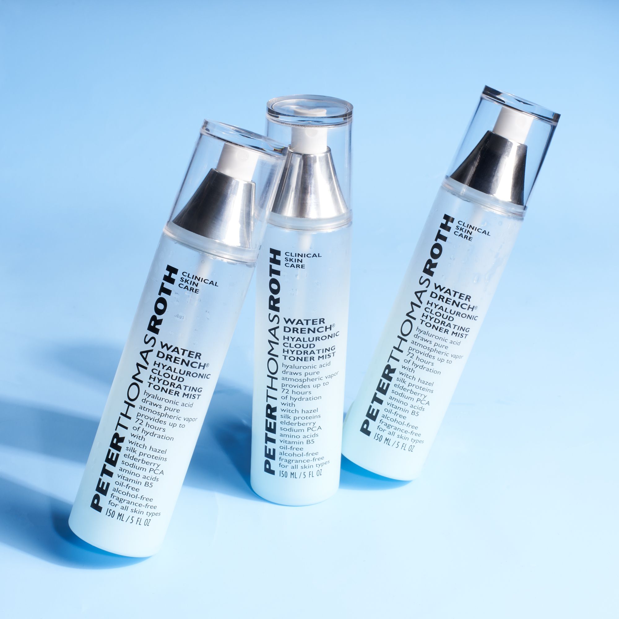 Tre flaconi Peter Thomas Roth Water Drench Hydrating Toner Mist. Su sfondo blu.