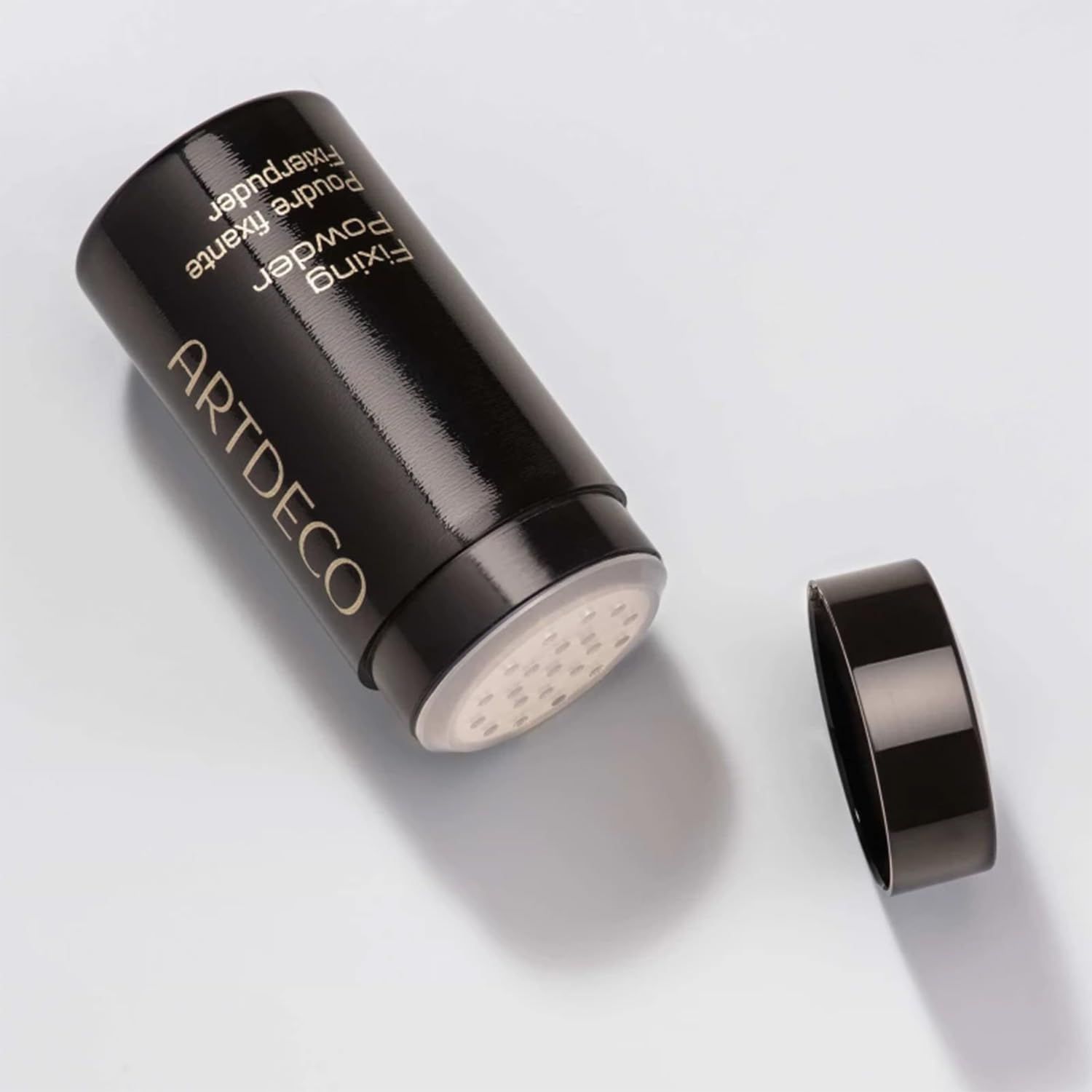 Contenitore nero di polvere fissante Artdeco aperto. Scritte: Fixing Powder, Poudre fixante, Fixierpuder.