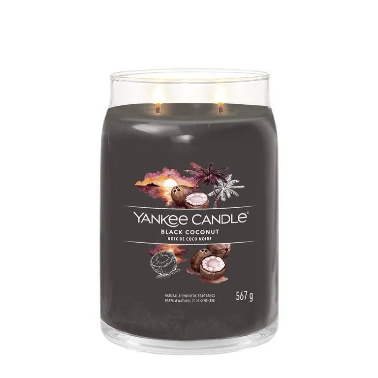 Candela grande, grigio scuro, con due stoppini. Etichetta con illustrazioni di cocco e nome del prodotto. Peso: 567 g.