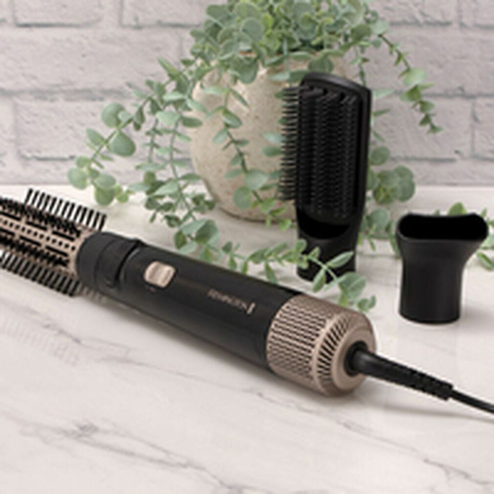 Remington Multi-Warmluftstyler con spazzola e accessori. Nero e oro. Su un tavolo con piante.