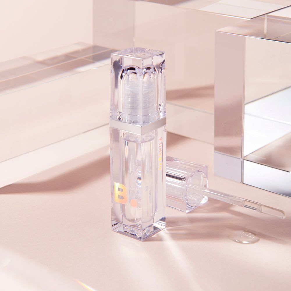 Flacone trasparente con nastro argentato e applicatore. Contiene un liquido limpido. Una lettera 'B' è visibile sul flacone.