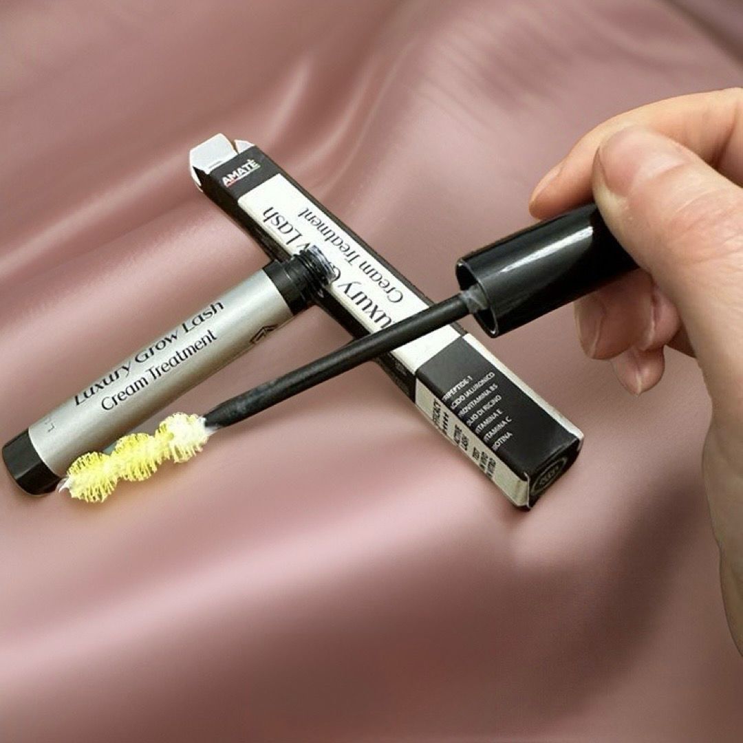Prodotto e spazzola. Testo: Luxury Grow Lash Cream Treatment. Mano che tiene la spazzola. Marchio: Amatè.