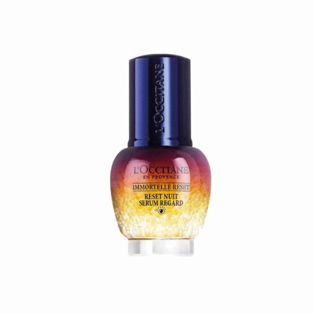 Flacone di siero con tappo blu. Scritte: L'Occitane, Immortelle Reset, Reset Nuit Serum Regard. Sferette gialle nella parte inferiore.