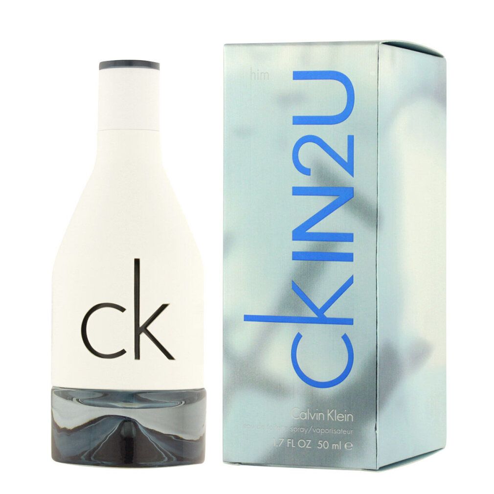Flacone di profumo bianco e scatola. Scritta: ck IN2U, Calvin Klein. Flacone con base argentata e tappo nero.