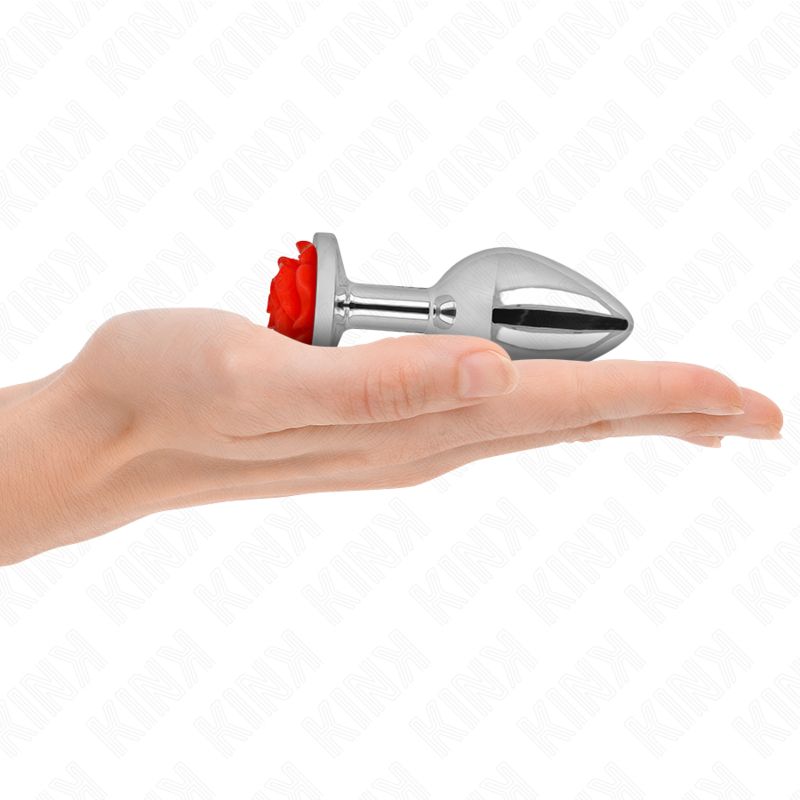 Plug anale in metallo con rosa rossa in una mano.
