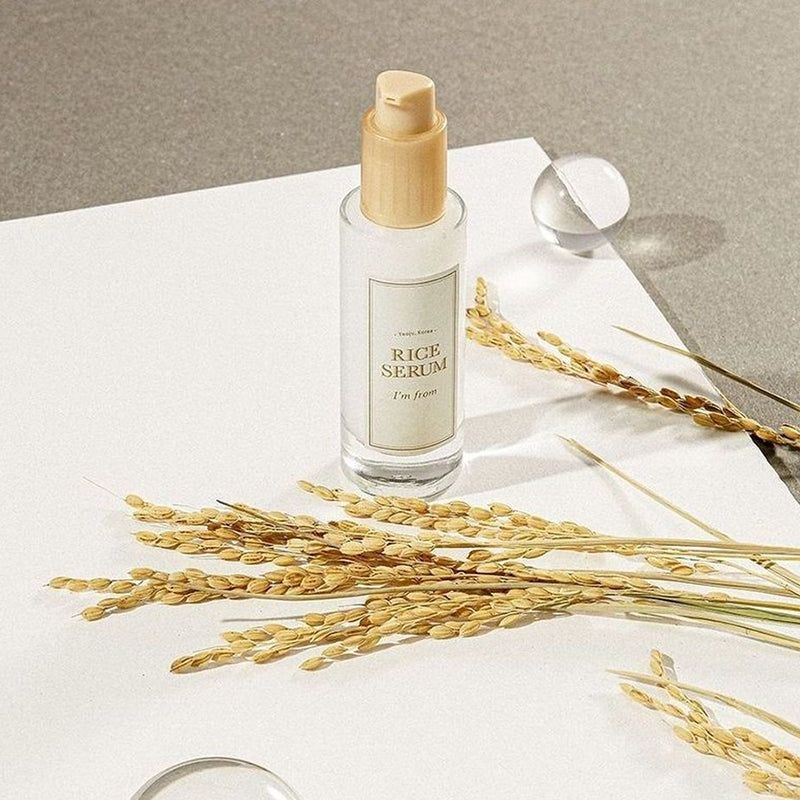 Flacone di siero con tappo in legno. Contiene « Rice Serum » e « I'm from ». Spighe di riso e sfera.