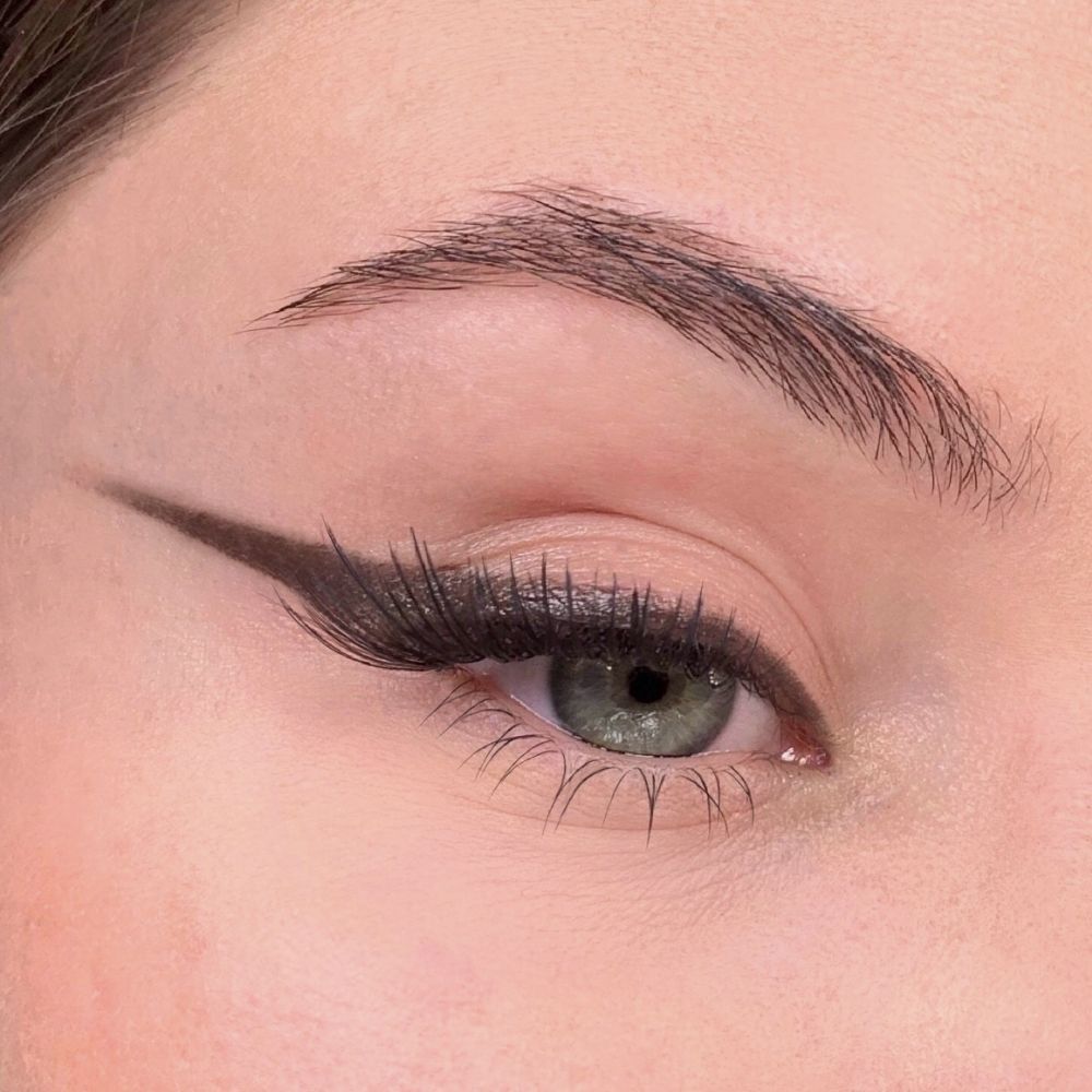 Occhio con eyeliner marrone. Eyeliner marrone sulla palpebra. Ciglia marroni. Sopracciglio.