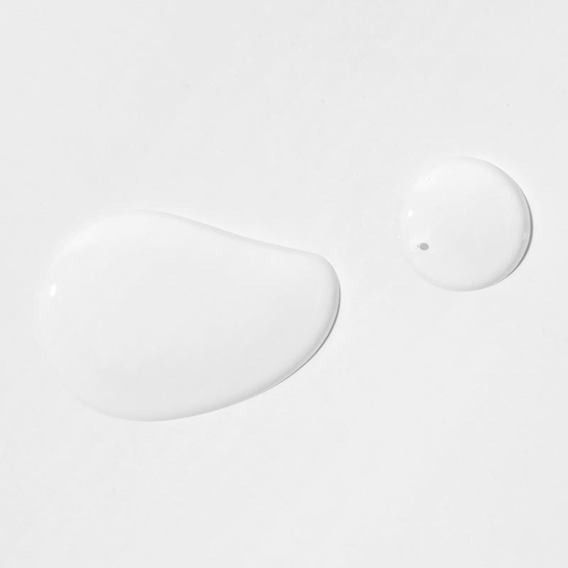 Due gocce di liquido trasparente su sfondo bianco. Una goccia è allungata, l'altra rotonda.