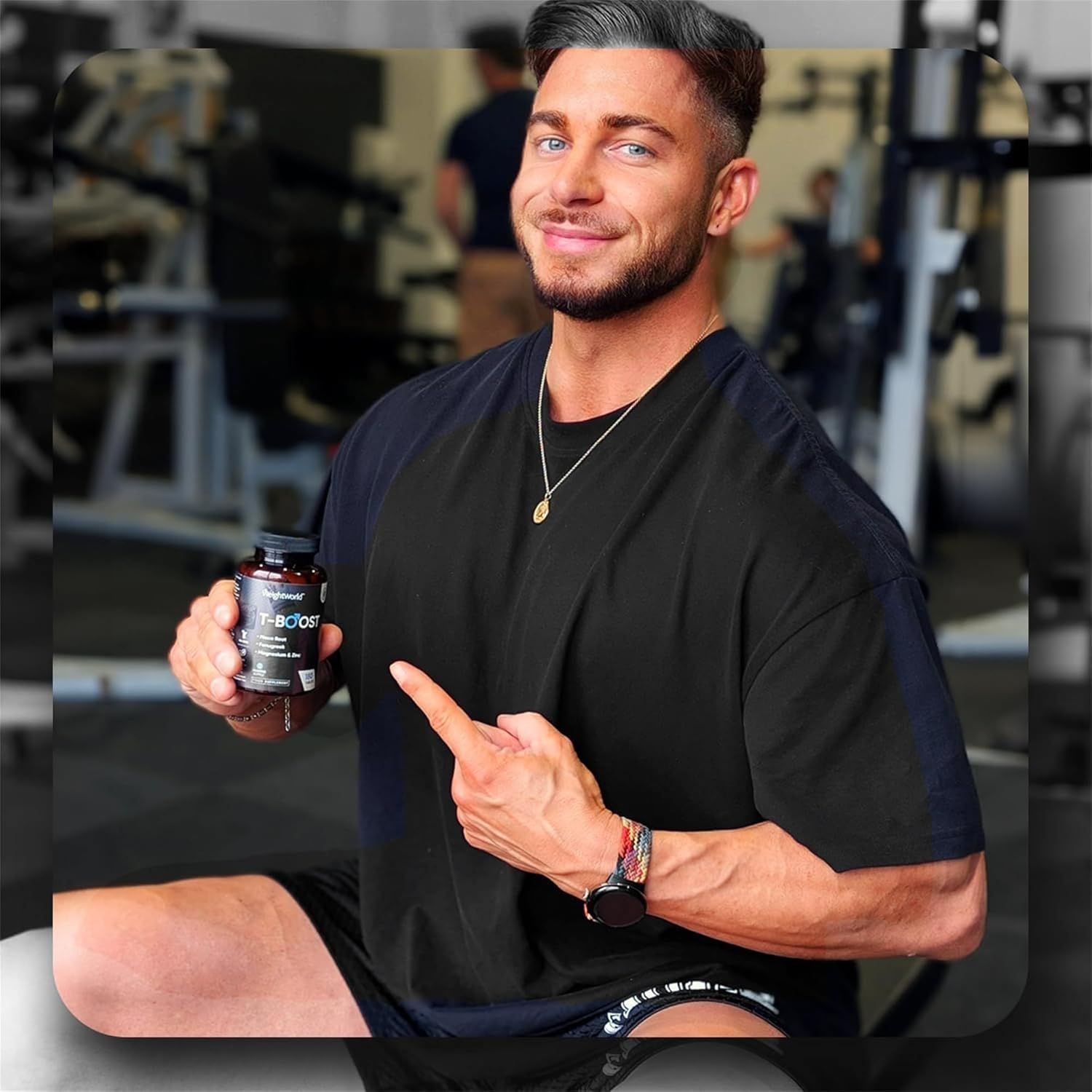 Uomo in palestra che tiene in mano un flacone di T-BOOST. Indica il flacone. Marchio WeightWorld.