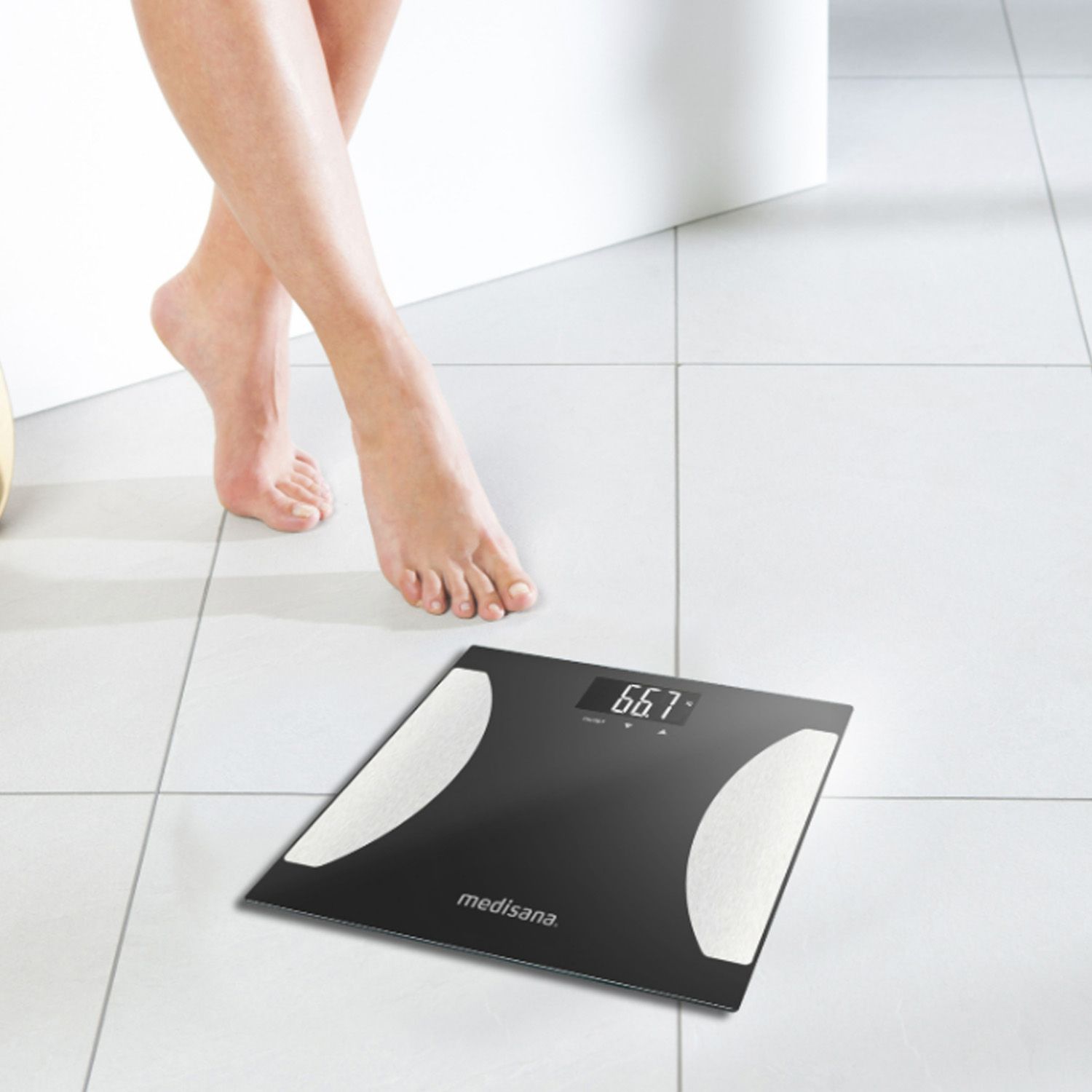 Bilancia per analisi corporea nera, con piedi di una persona. Display 66.7. Marca: Medisana.