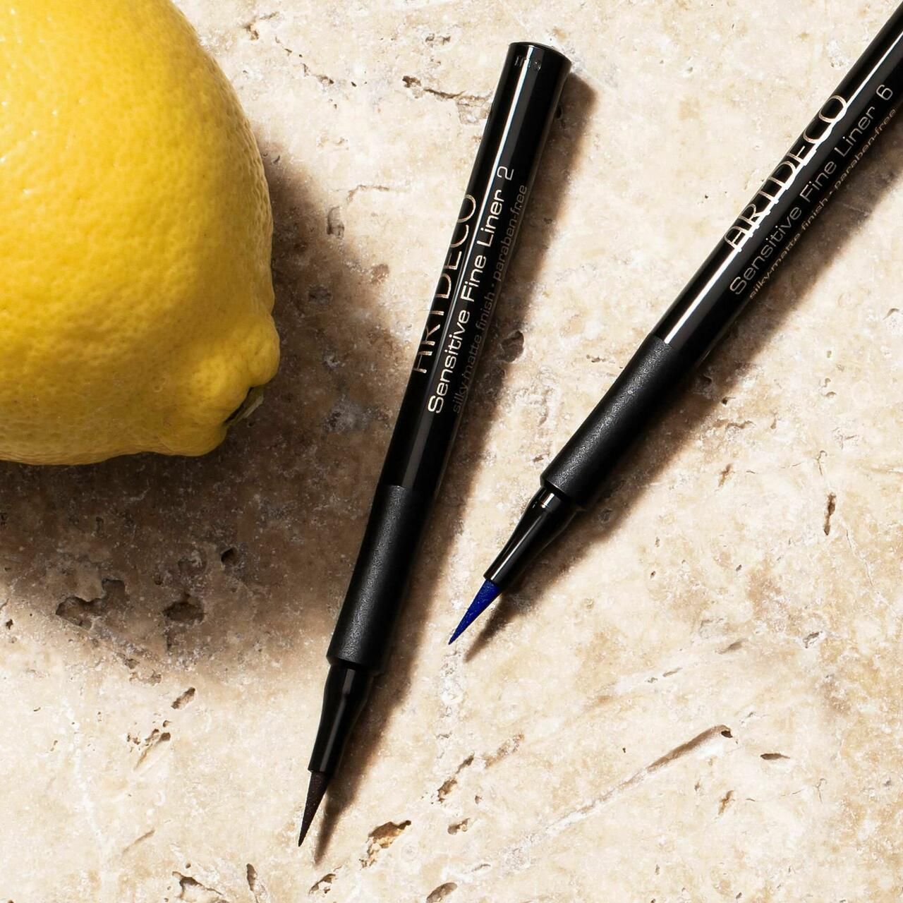 Due Artdeco Sensitive Fine Liner, uno con punta nera, uno con punta blu. Penne nere, nome del prodotto visibile.