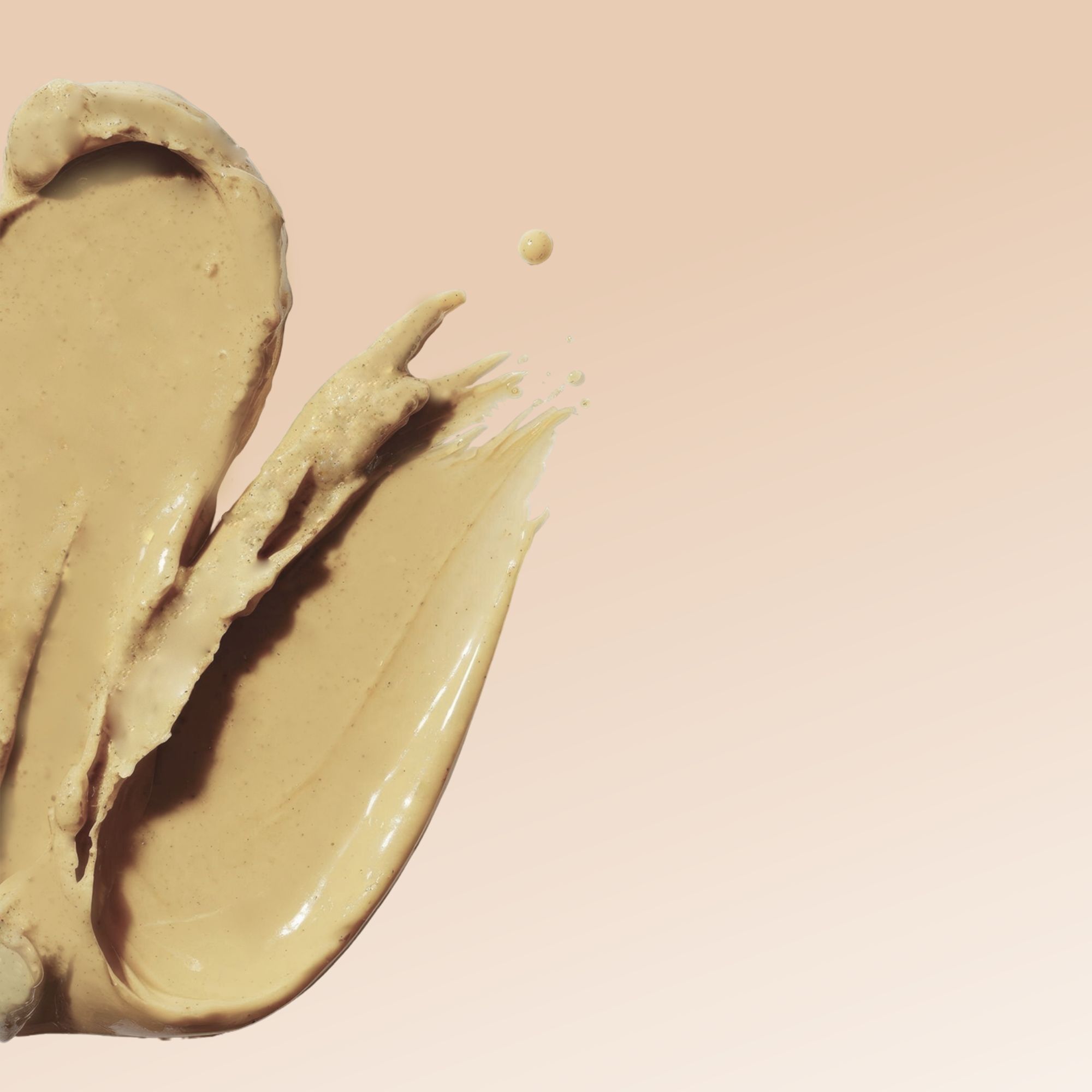 Texture crema beige spalmata. Una goccia. Su sfondo rosa-beige.