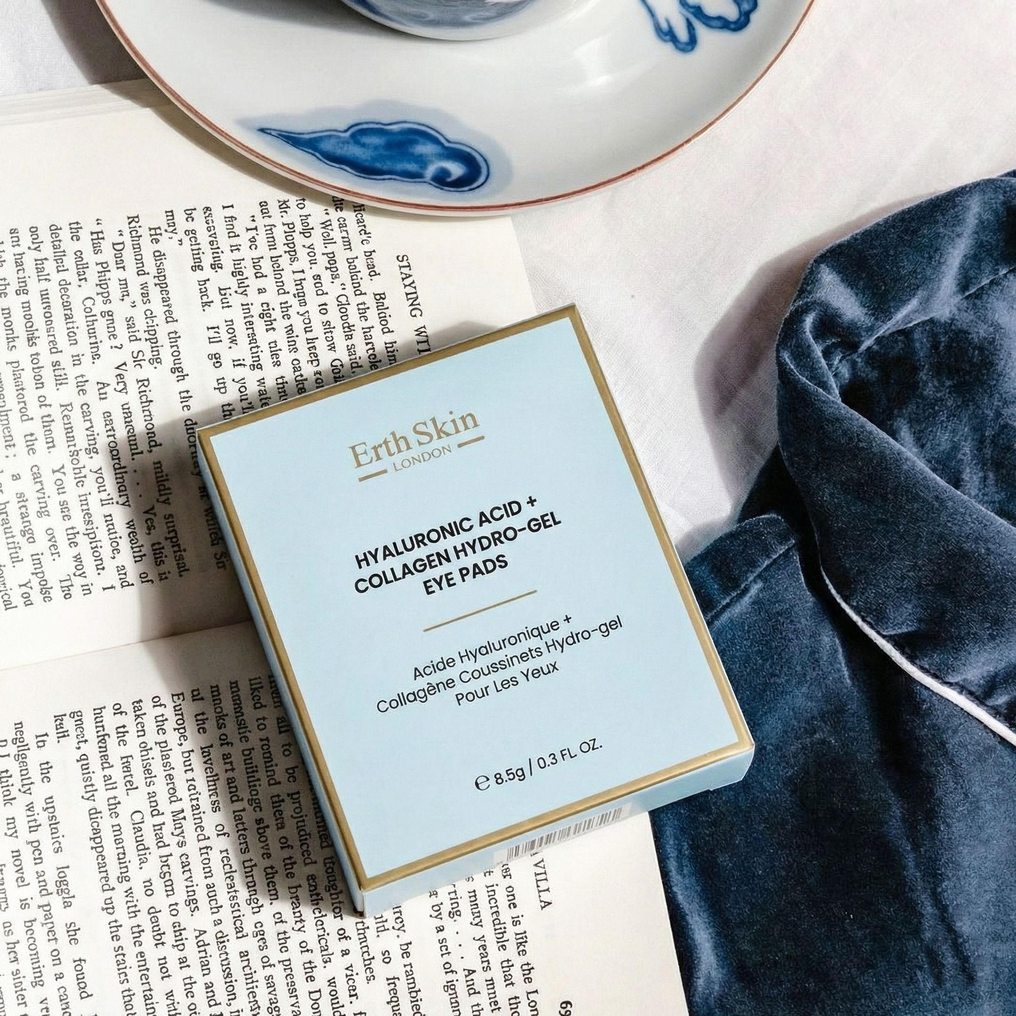 Confezione di patch oculari idrogel acido ialuronico + collagene ErthSkin London, appoggiata su un libro.