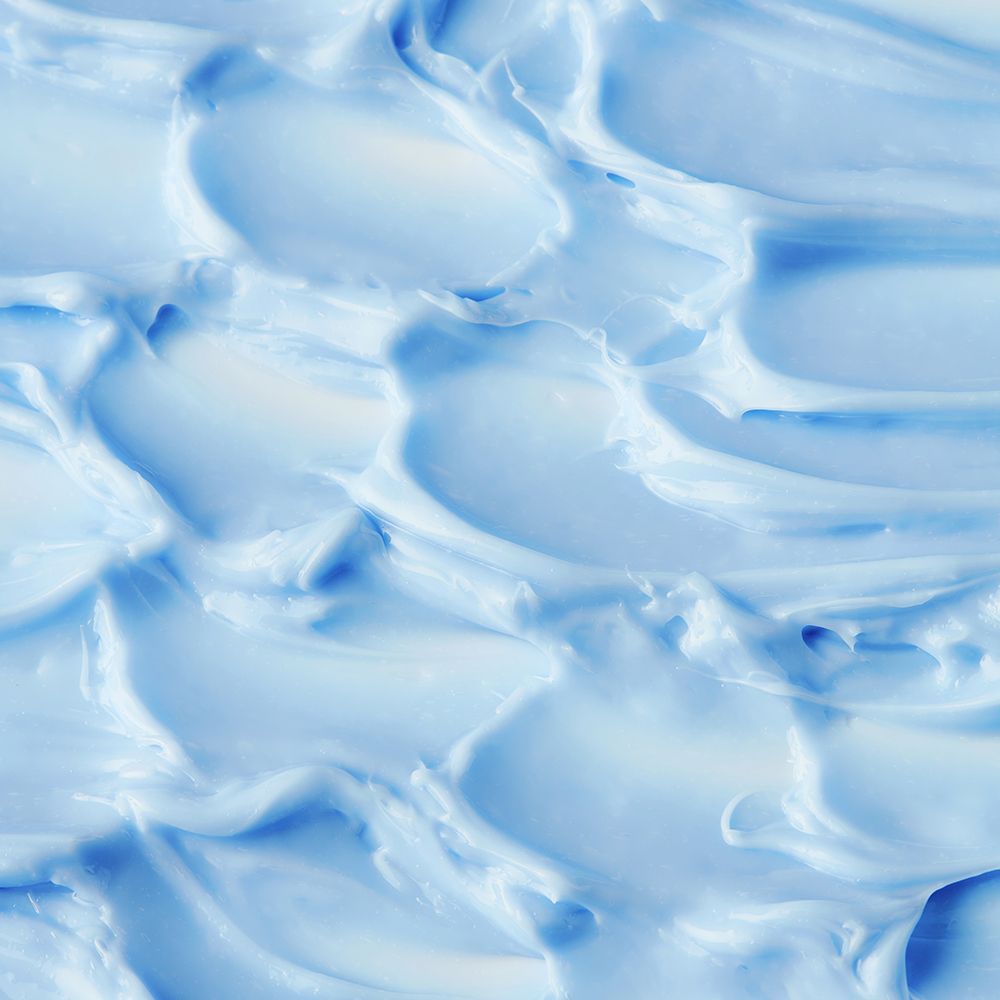 Prodotto per la cura della pelle blu e cremoso, in primo piano.