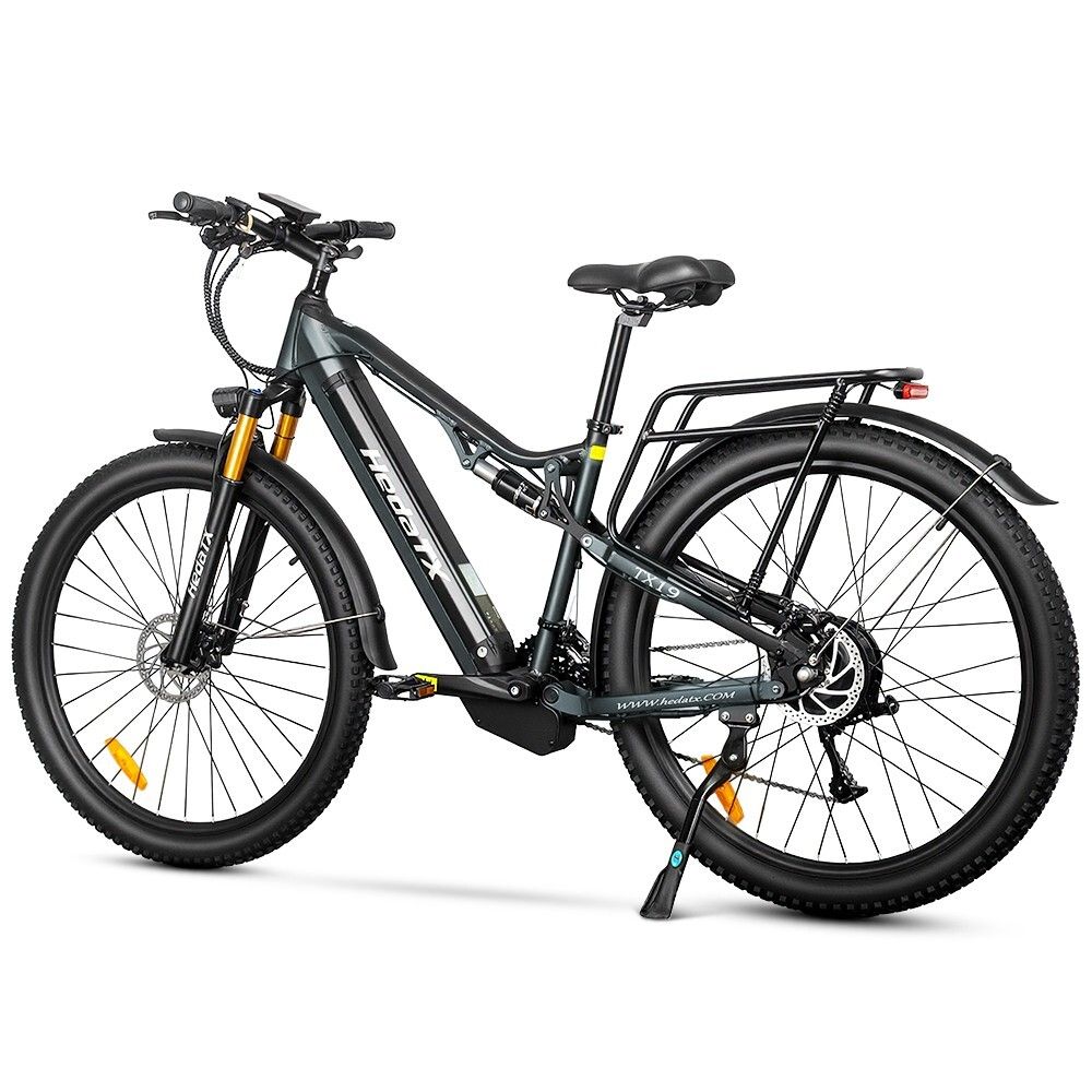 E-bike grigio HedaTX TX19. Pneumatici neri, portapacchi, sospensioni. Forcella gialla. 27 velocità. Scritta HedaTX.