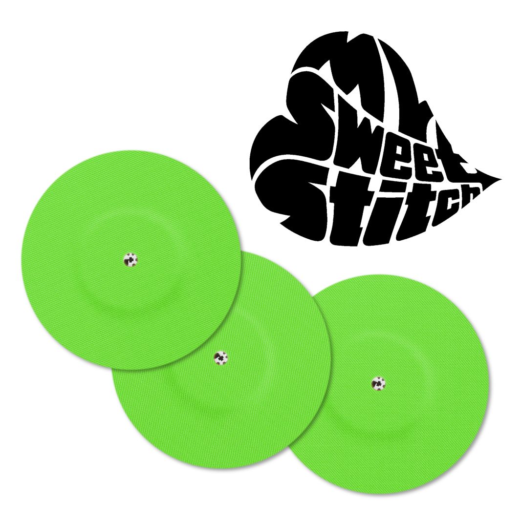 Tre cerotti di fissaggio verdi con foro di ventilazione. Logo a forma di cuore. Su sfondo bianco.