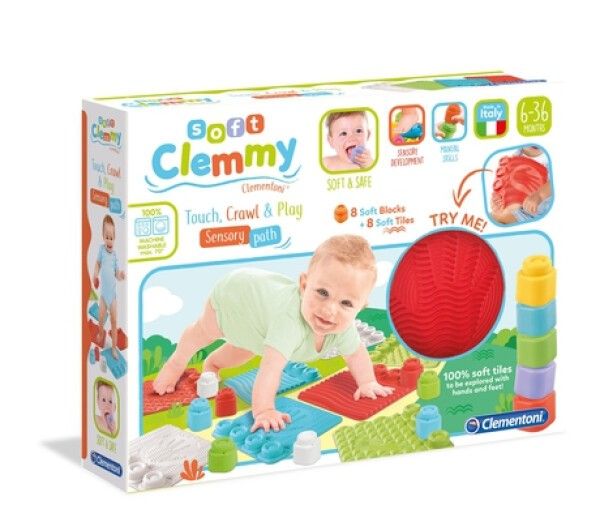Confezione gioco Clemmy. Include blocchi morbidi, piastrelle e una palla rossa. Bambino che gattona sul tappeto. Testo: Soft Clemmy, 6-36 mesi.
