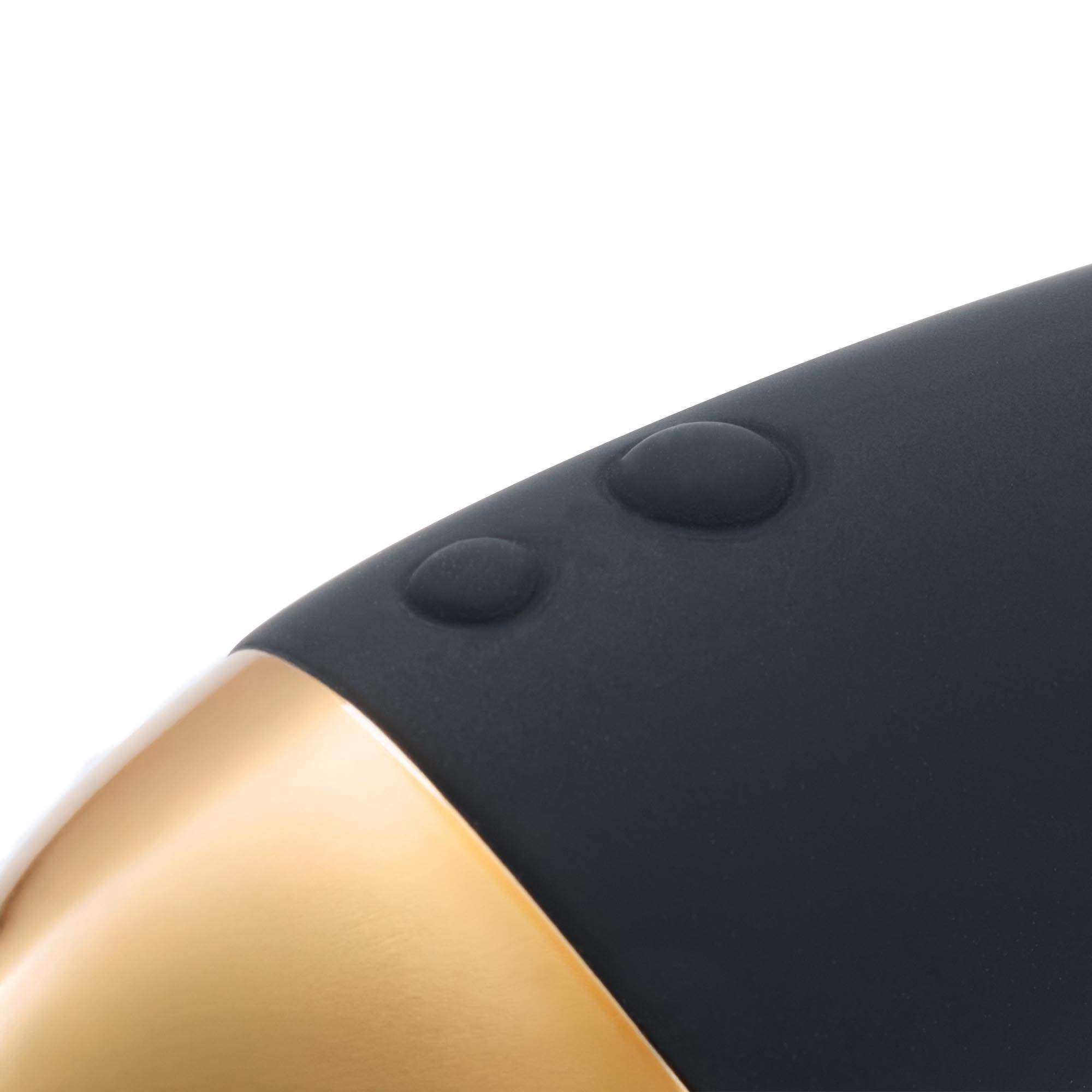 Primo piano di una bacchetta massaggiante nera con due pulsanti in rilievo e un dettaglio dorato.