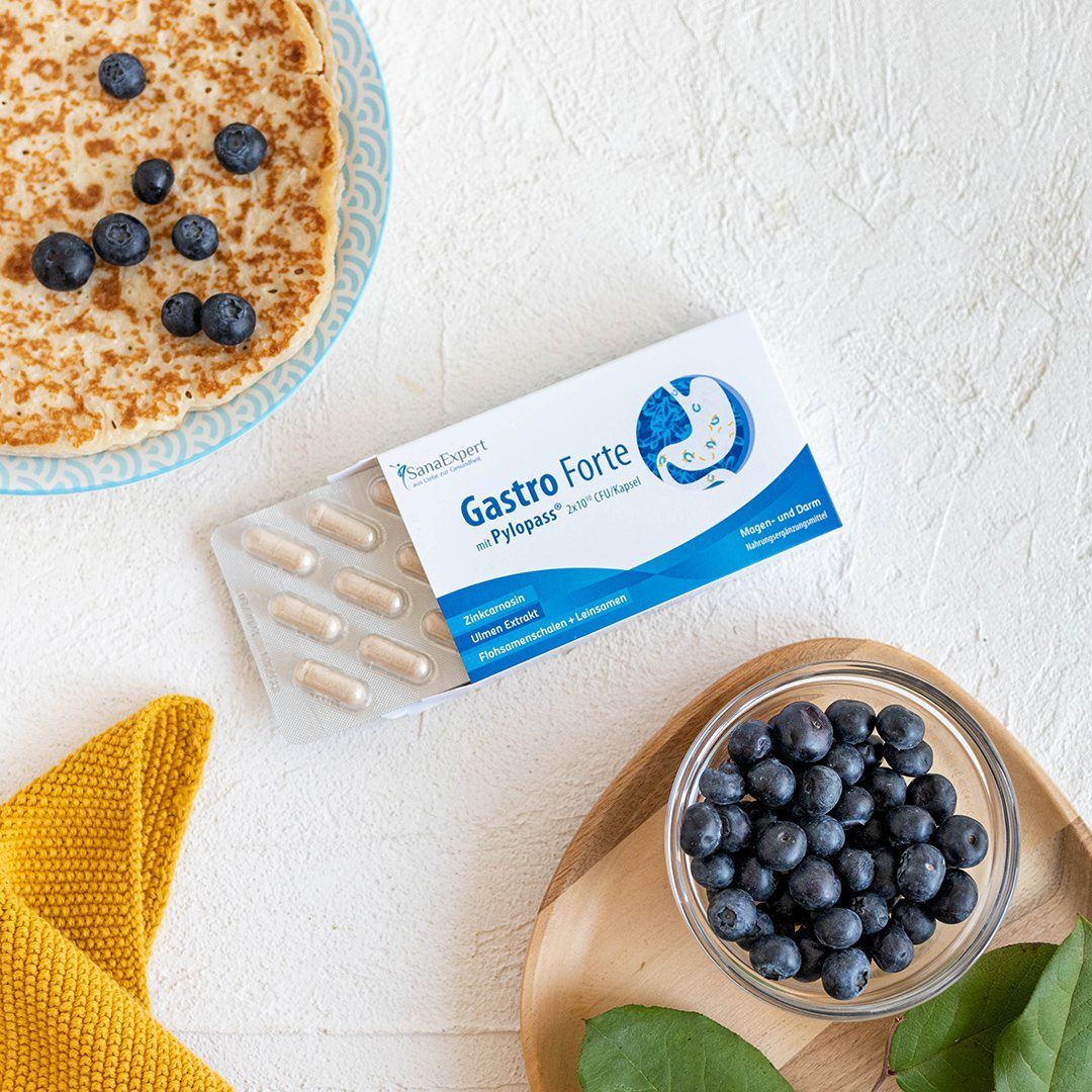 Confezione con capsule e mirtilli. Sulla confezione c'è scritto Gastro Forte.