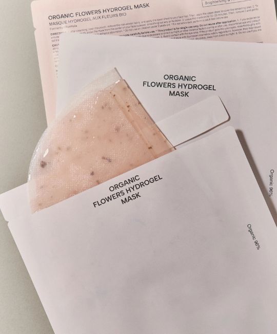 Confezioni aperte con maschere viso. Stampa: ORGANIC FLOWERS HYDROGEL MASK.