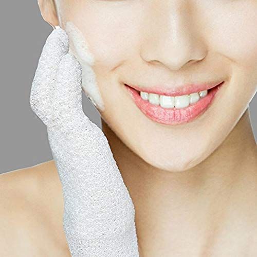 Una persona usa un guanto esfoliante bianco per pulire il viso con la schiuma.