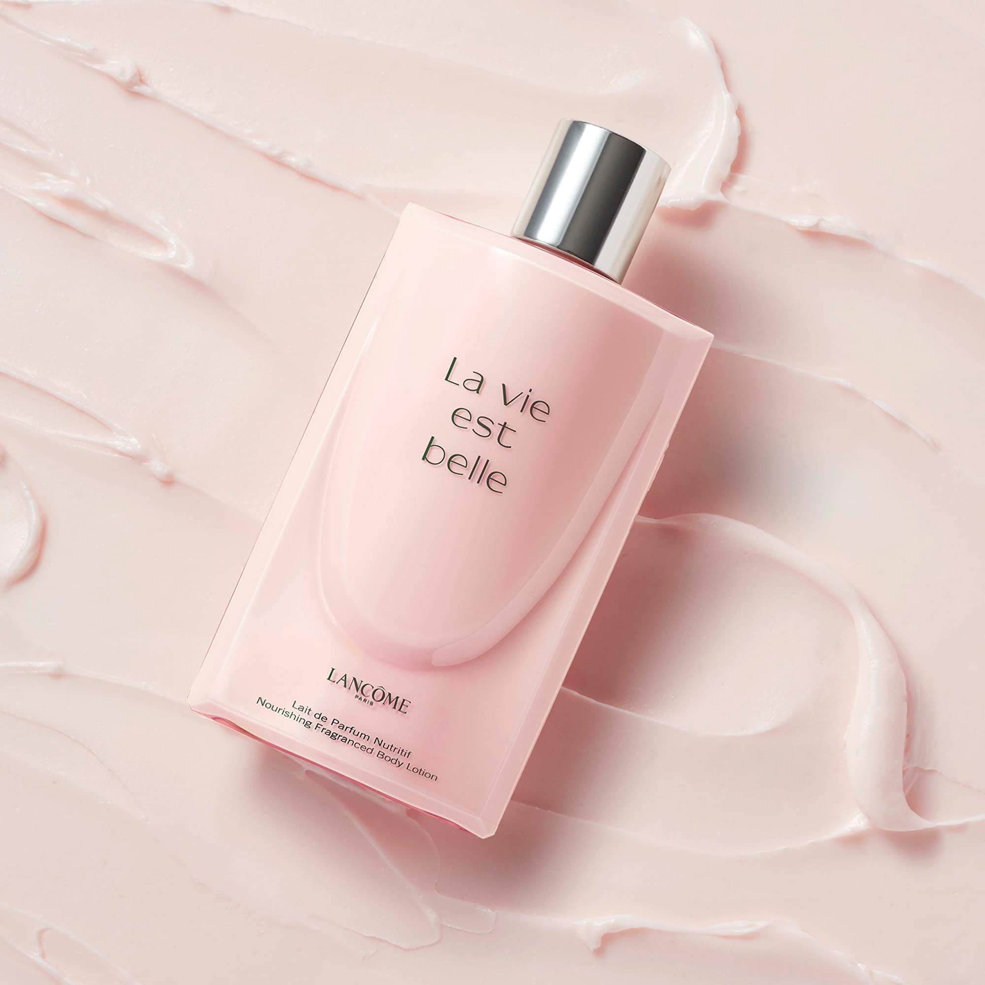 Flacone di lozione per il corpo rosa su sfondo rosa. Scritta: La vie est belle e Lancôme.