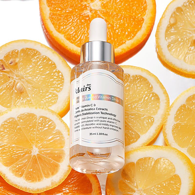 Flacone di siero Klairs con agrumi. Vetro trasparente, tappo argentato, etichetta bianca. Arance e limoni.