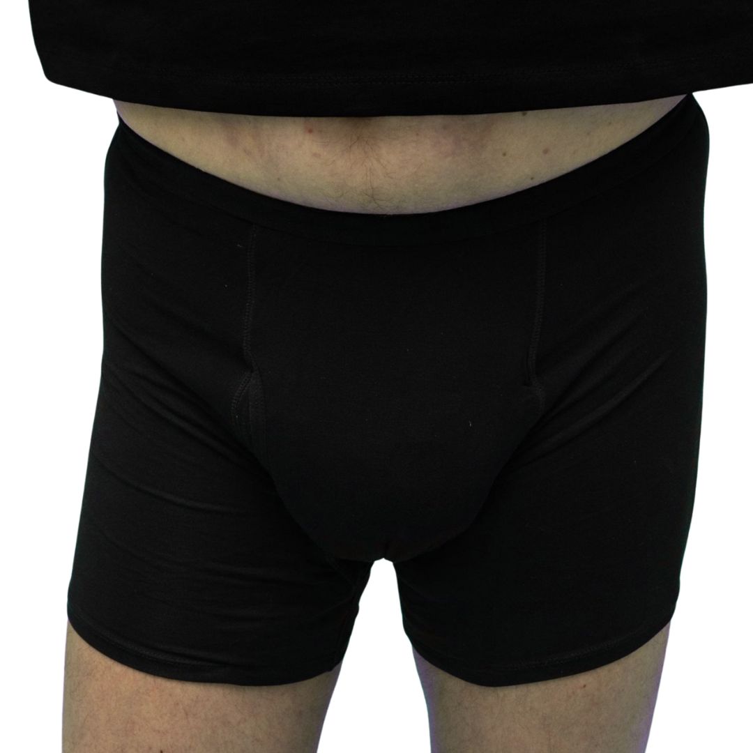 Primo piano: uomo in boxer neri. Cintura elastica, tessuto drappeggiato.
