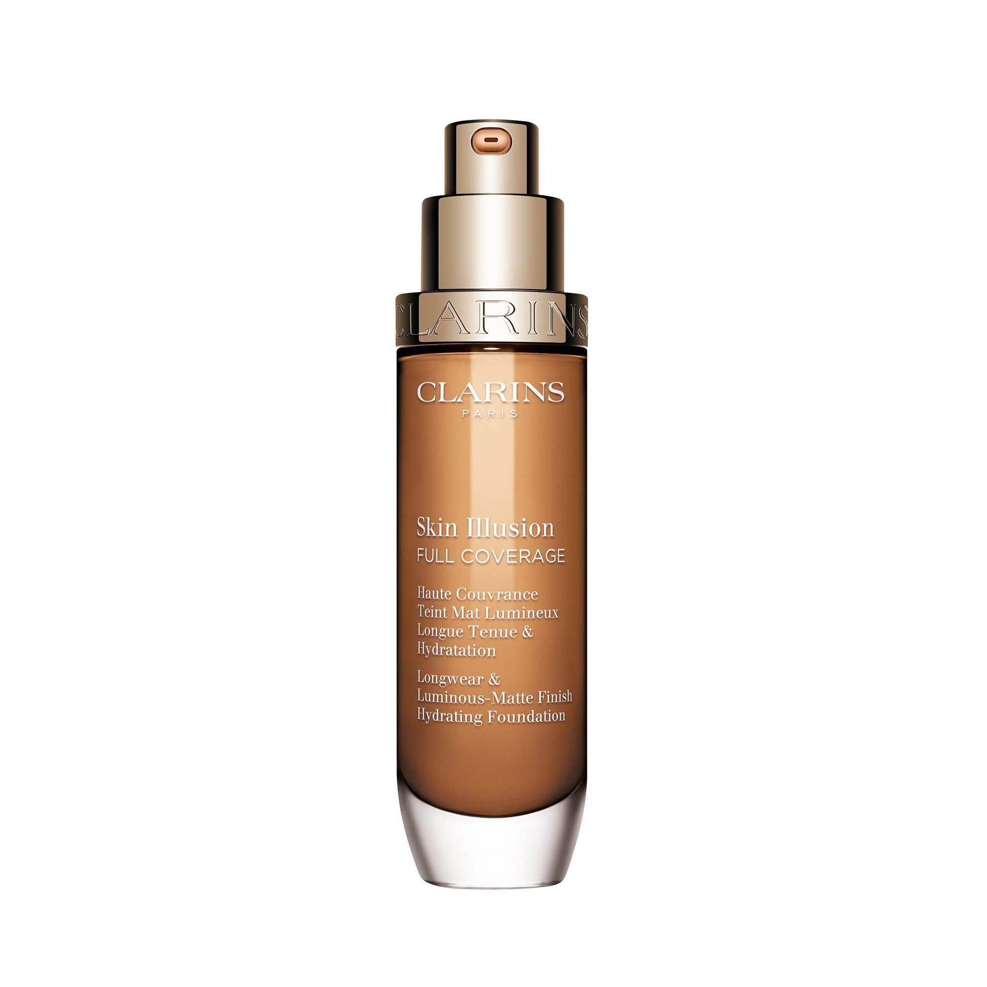 Fondotinta Clarins Skin Illusion Full Coverage 114N, flacone in vetro con tappo dorato. Etichetta del prodotto visibile.