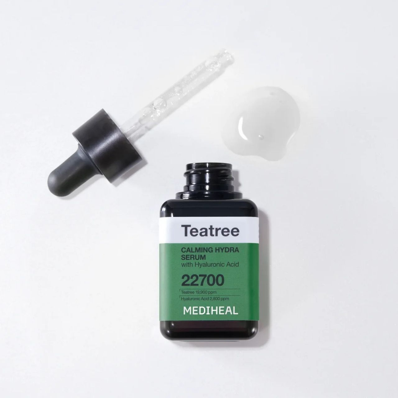 Flacone di siero idratante lenitivo al tea tree MEDIHEAL con contagocce e goccia di siero accanto.