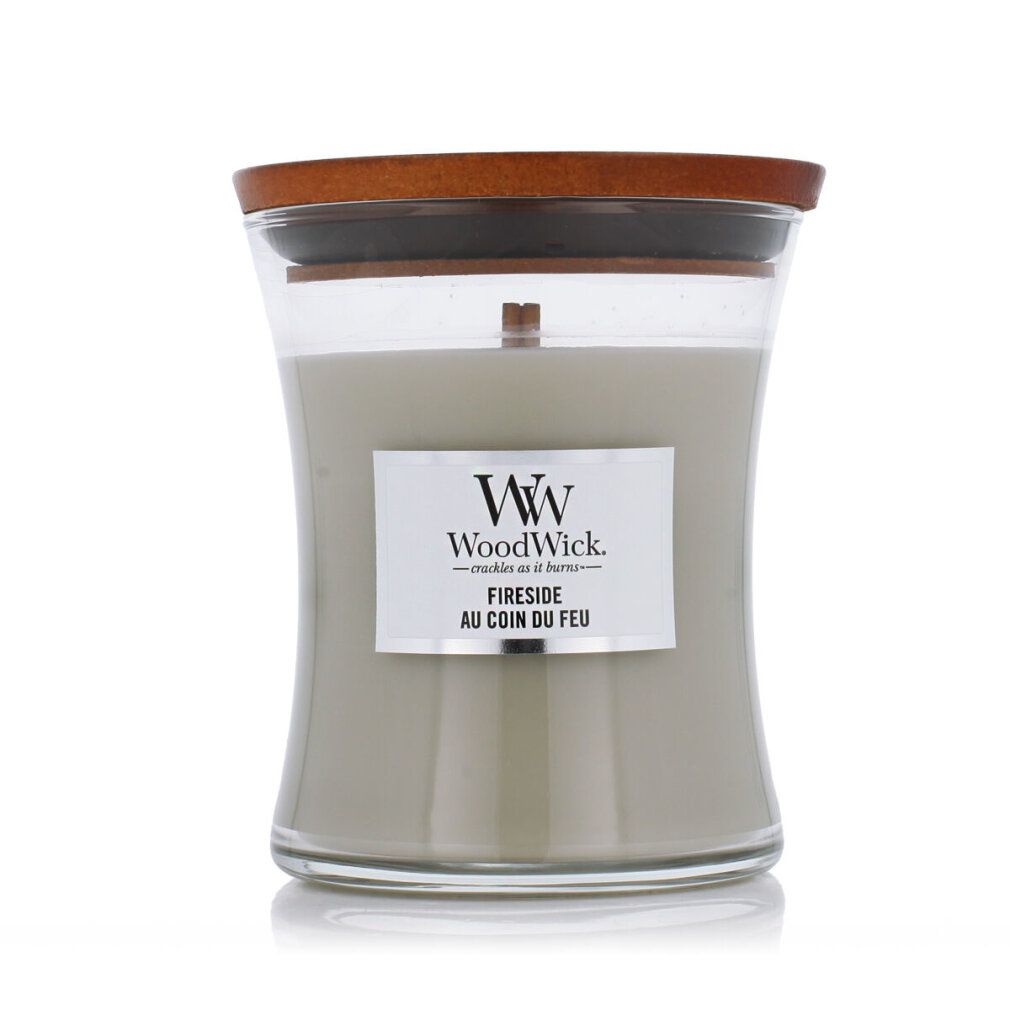 Candela a clessidra con coperchio in legno. Cera grigia, etichetta bianca con logo WoodWick e scritta 'Fireside au coin du feu'.