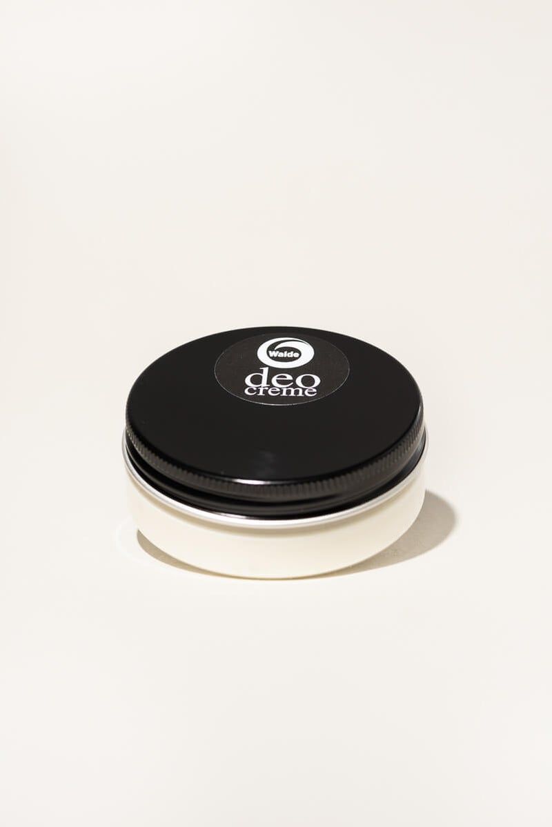 Barattolo rotondo con coperchio nero. Sulla parte superiore, un adesivo con la scritta "deo creme" e il logo "Walde".