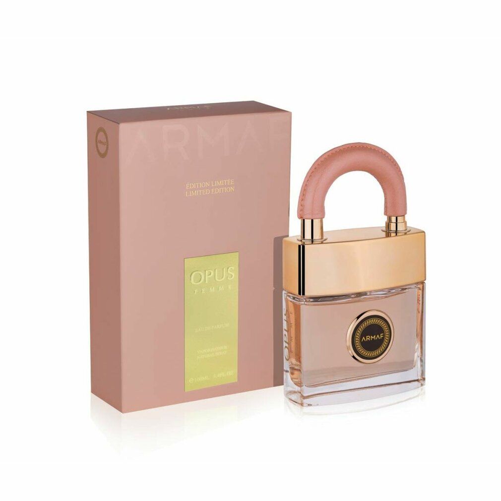 Flacone di profumo con tappo color oro e manico rosa, accanto a una scatola rosa abbinata con scritte dorate.